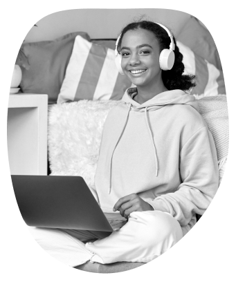 teen in sweater with headphones and laptop in black and white