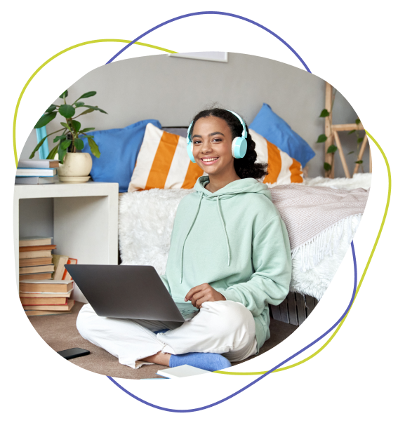 Populations We Support - teen in sweater with headphones and laptop