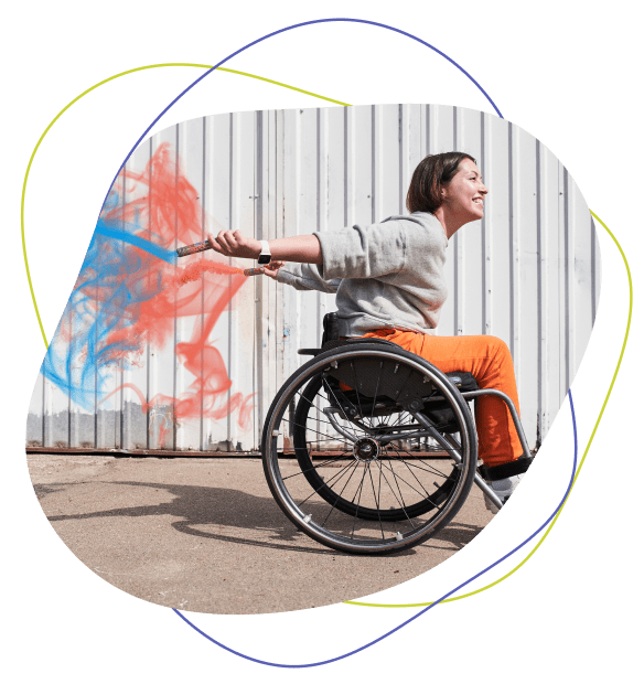 woman in a wheelchair with colourful smoke behind her