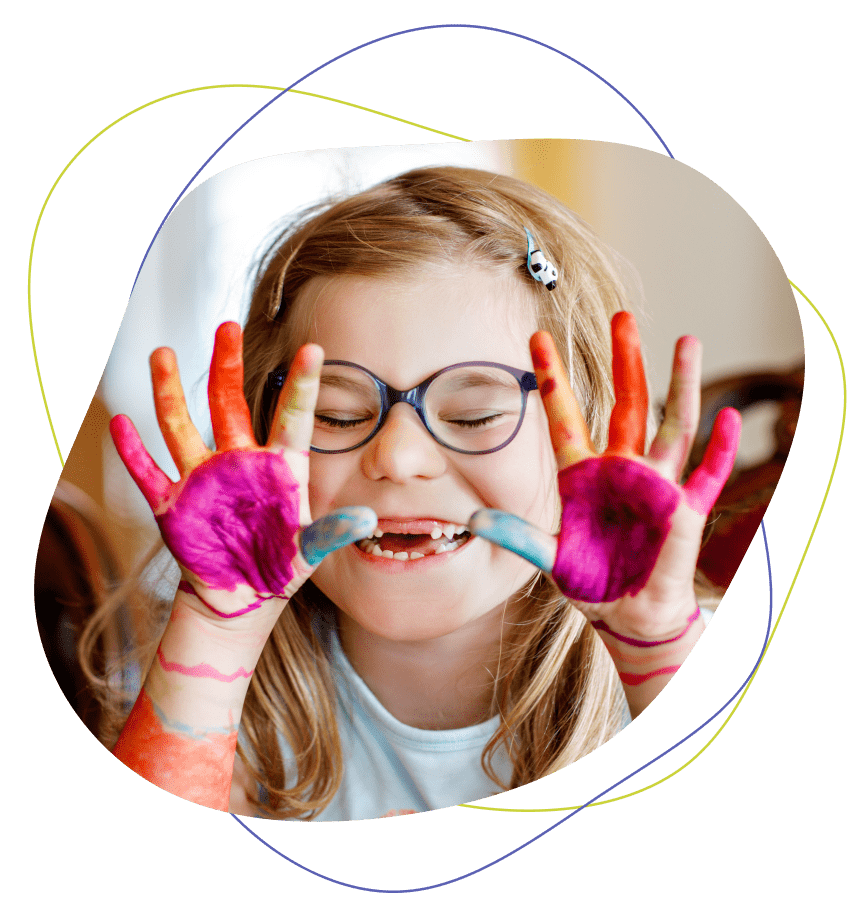 Happy child with paint on her hands during a child therapy art lesson